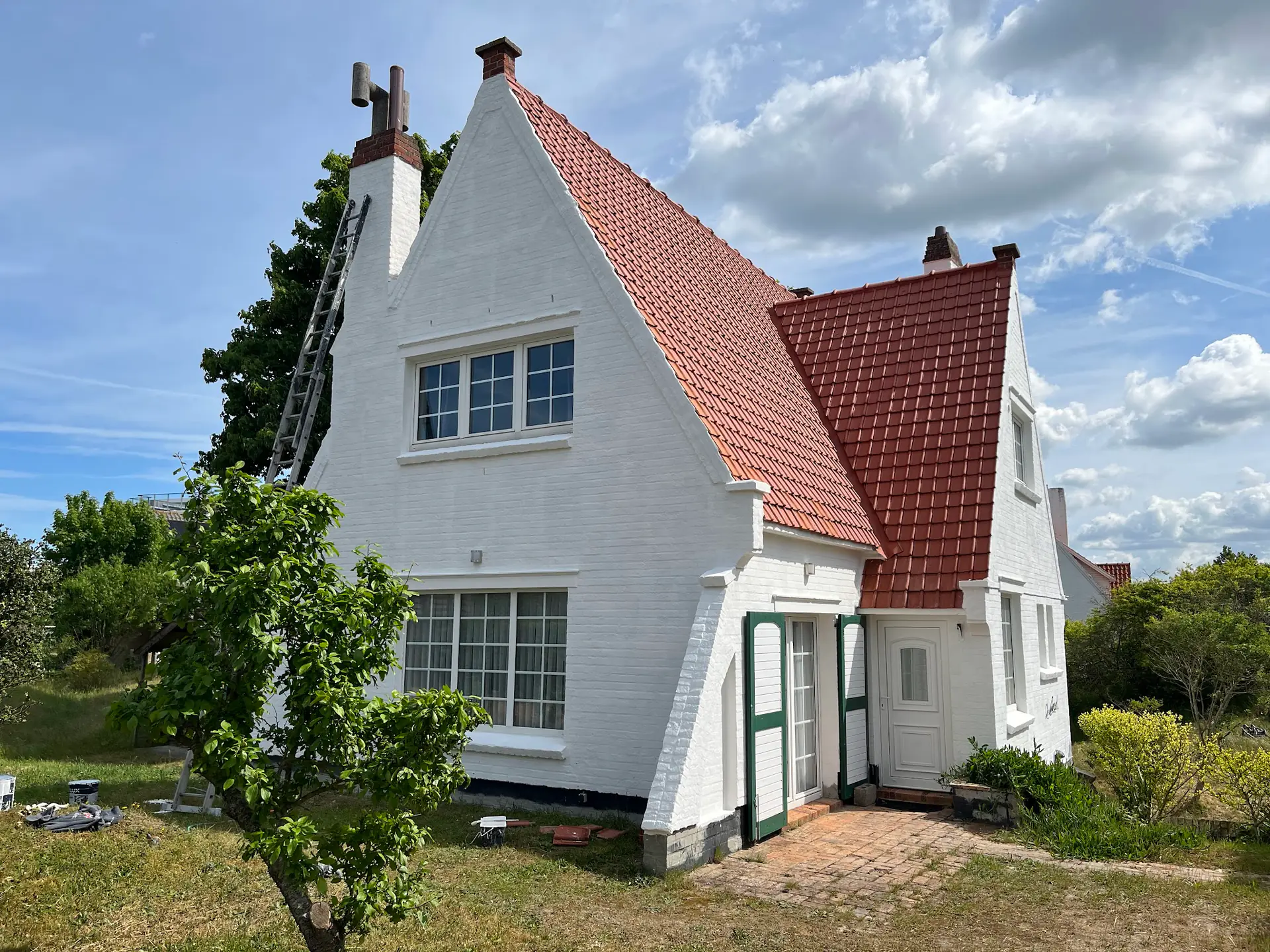 Maison rénovée : façade repeinte en blanc et toiture en tuiles neuves